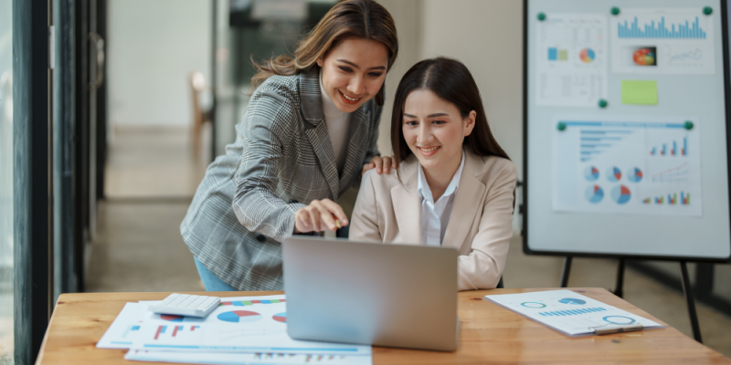 a group of women looking at a laptop