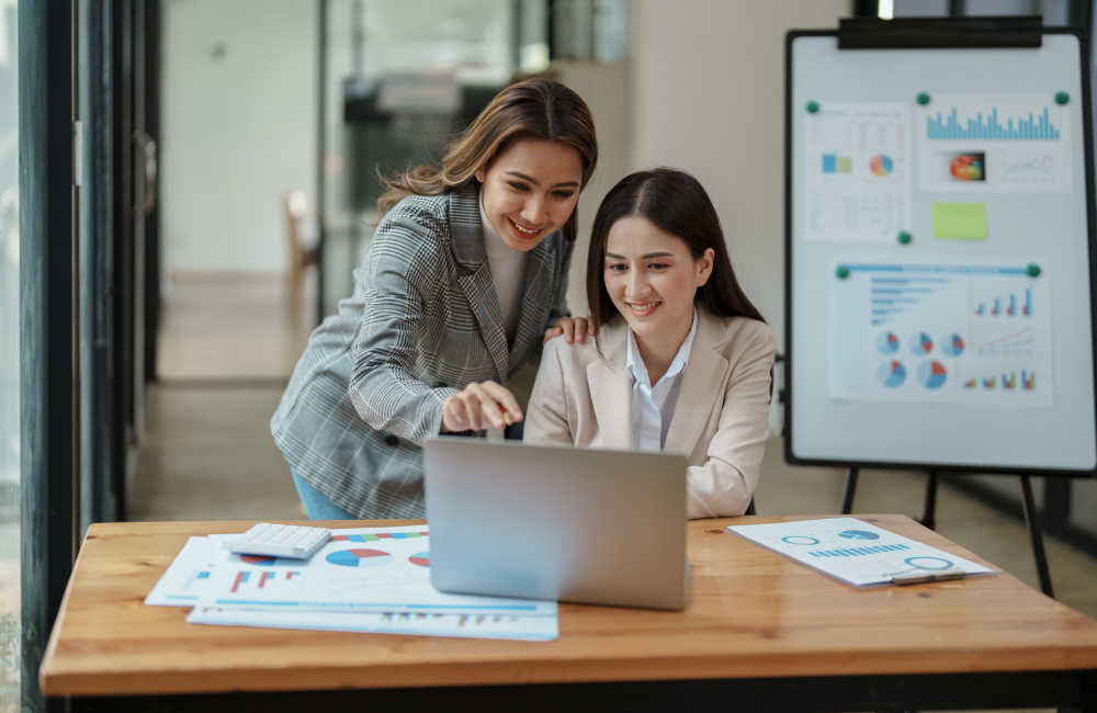 a group of women looking at a laptop