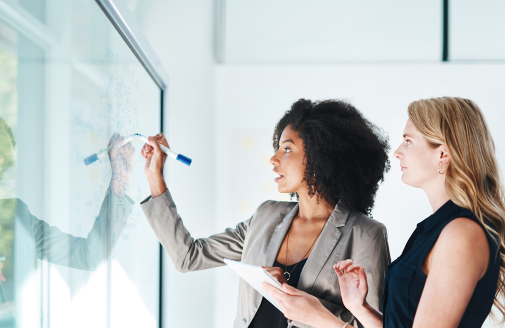 a group of women writing on a whiteboard